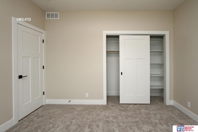 unfurnished bedroom featuring light carpet and a closet