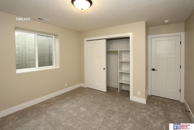 unfurnished bedroom featuring carpet flooring, a closet, and a textured ceiling