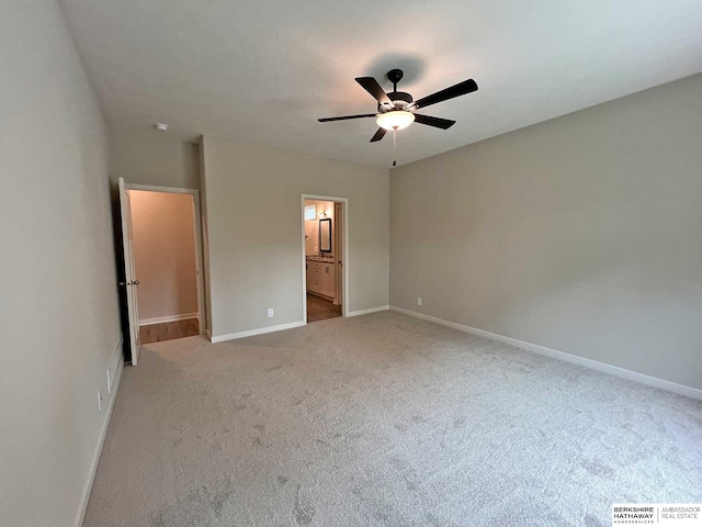 unfurnished bedroom with ceiling fan, ensuite bathroom, and light carpet