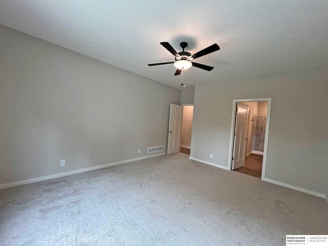 unfurnished bedroom featuring connected bathroom, ceiling fan, and light colored carpet