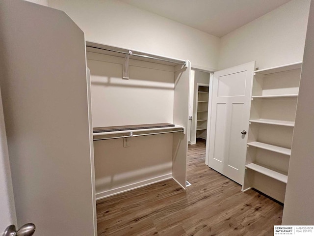 walk in closet with hardwood / wood-style floors