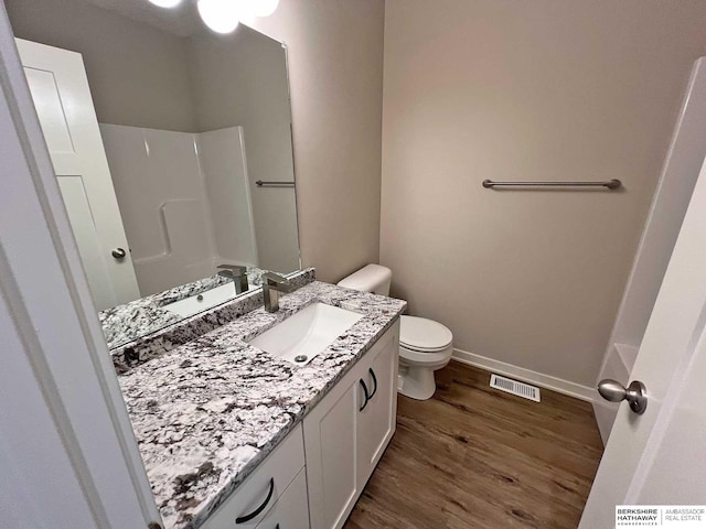 bathroom featuring toilet, vanity, and hardwood / wood-style flooring