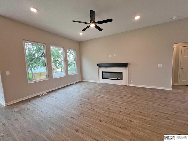 unfurnished living room with hardwood / wood-style flooring and ceiling fan