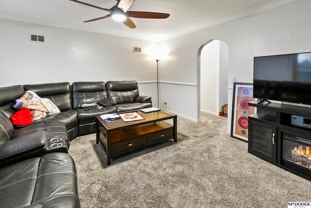 living room with light carpet, ceiling fan, and ornamental molding