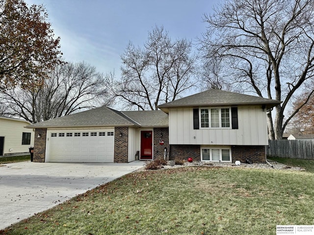 tri-level home with a garage and a front lawn