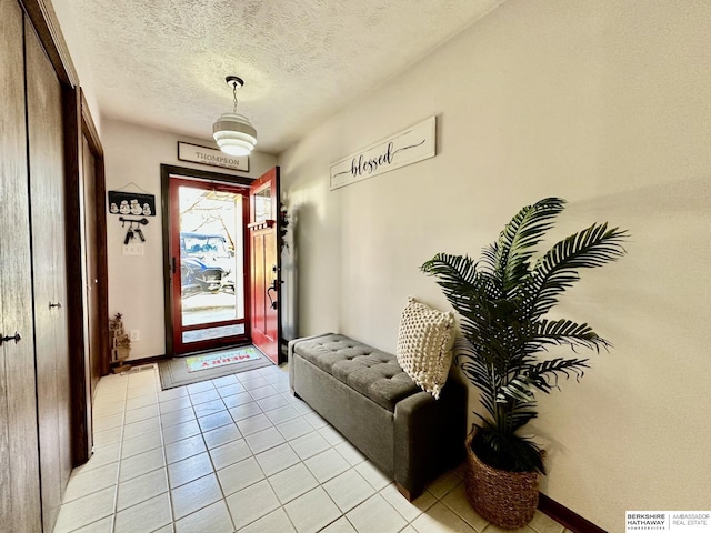 tiled entrance foyer featuring a textured ceiling