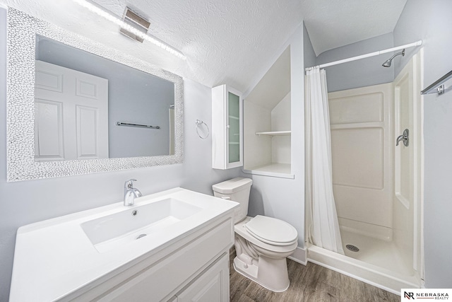 bathroom with a shower with curtain, wood-type flooring, a textured ceiling, and vanity