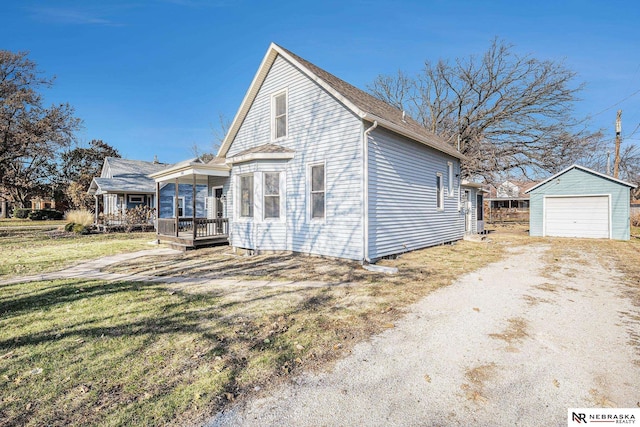 view of front of house featuring a porch, a front yard, an outdoor structure, and a garage