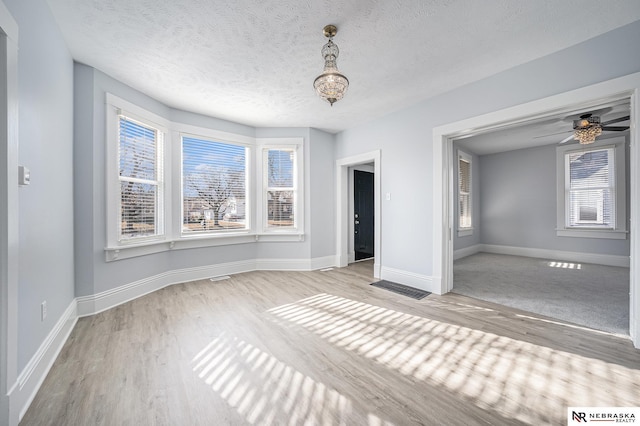 unfurnished bedroom featuring a textured ceiling and light wood-type flooring