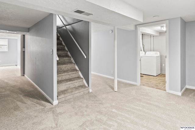 basement featuring separate washer and dryer and light colored carpet