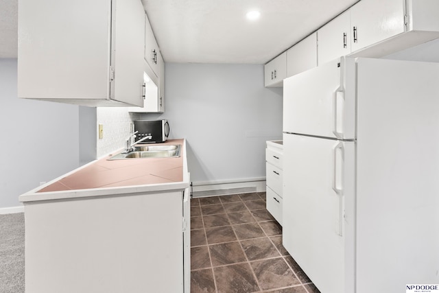 kitchen with white cabinets, white fridge, and sink