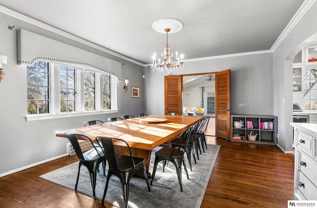 dining area with dark hardwood / wood-style flooring, crown molding, and an inviting chandelier