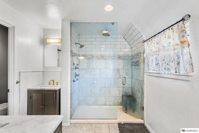 bathroom with tile patterned flooring, vanity, a shower with shower door, and toilet