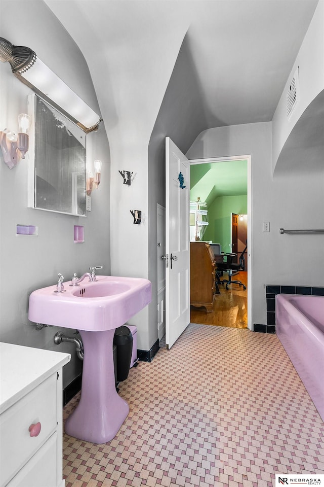 bathroom featuring lofted ceiling