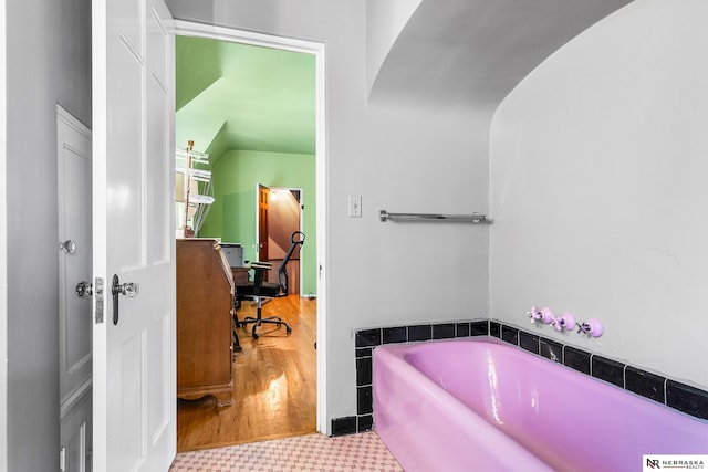 bathroom with tile patterned flooring and a bath