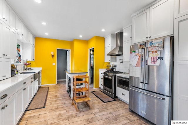 kitchen featuring decorative backsplash, white cabinetry, wall chimney exhaust hood, and stainless steel appliances