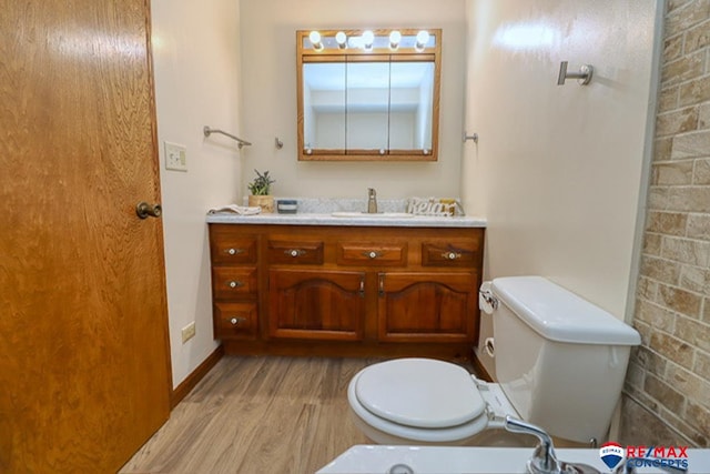 bathroom featuring toilet, vanity, and hardwood / wood-style flooring