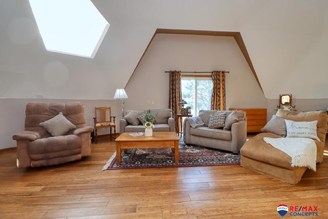 living room with lofted ceiling with skylight and light hardwood / wood-style floors