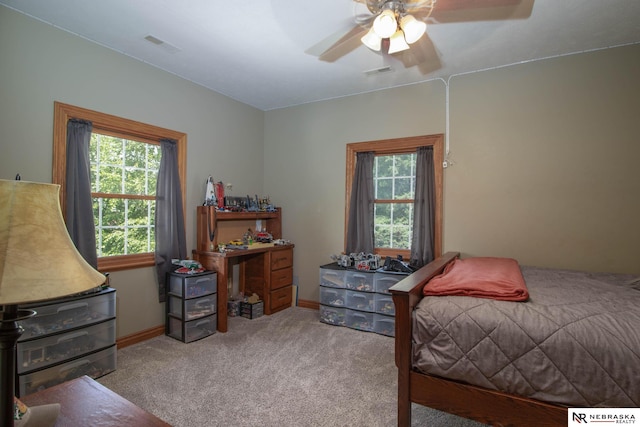bedroom featuring multiple windows, ceiling fan, and light colored carpet