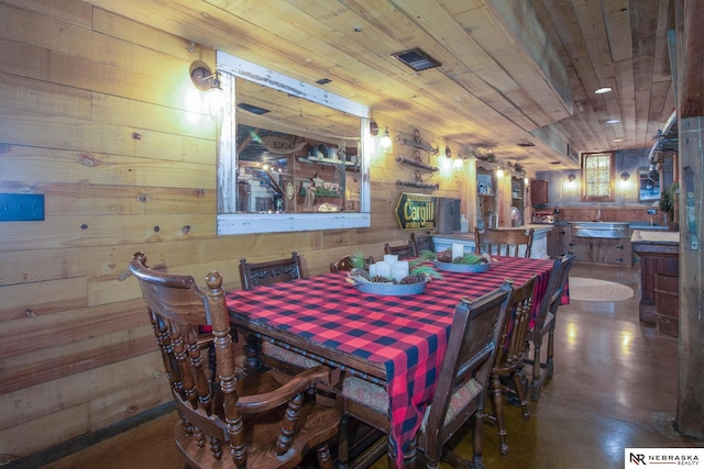 dining space with wooden ceiling and wooden walls