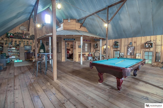 game room with wood walls, hardwood / wood-style floors, vaulted ceiling, and billiards