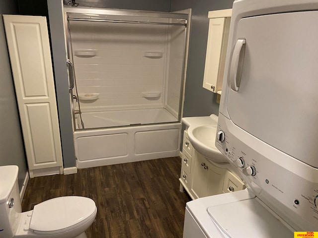 full bathroom with hardwood / wood-style floors, vanity, shower / tub combination, stacked washer and dryer, and toilet