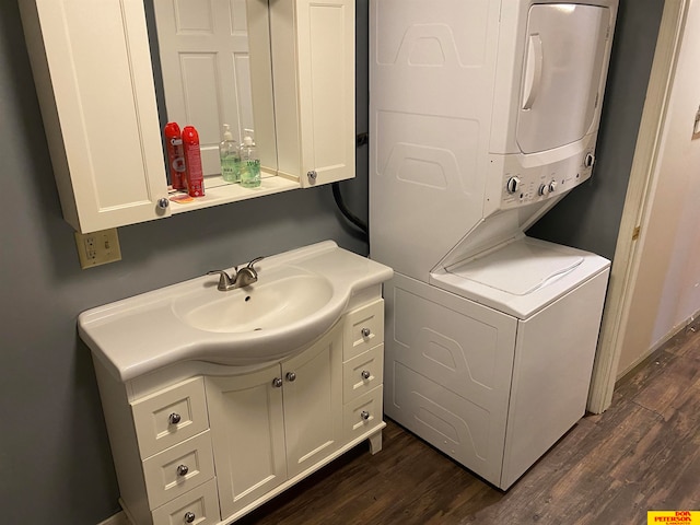 laundry room featuring dark wood-type flooring and stacked washer and clothes dryer