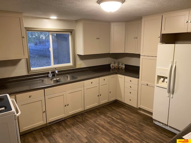 kitchen with stove, sink, dark hardwood / wood-style floors, white fridge with ice dispenser, and a textured ceiling