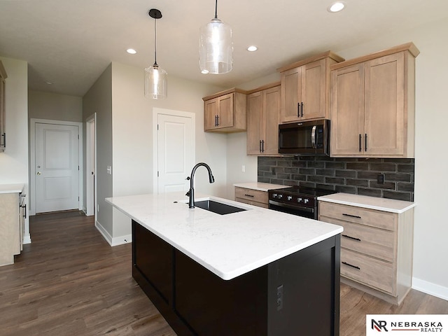 kitchen with light brown cabinets, a kitchen island with sink, stainless steel electric stove, sink, and hanging light fixtures