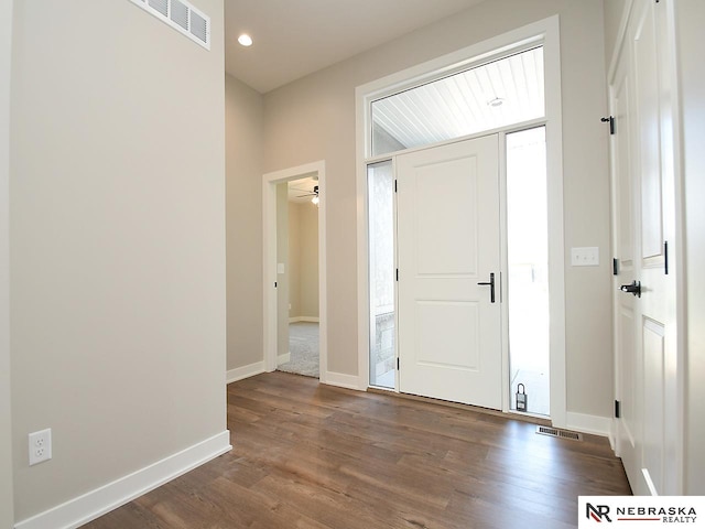 foyer entrance featuring ceiling fan and dark wood-type flooring