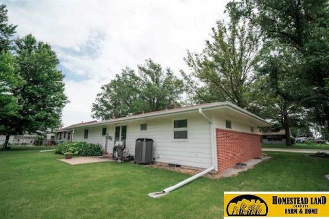 back of property with a yard and central AC