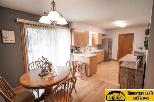 dining room with light hardwood / wood-style flooring and a notable chandelier