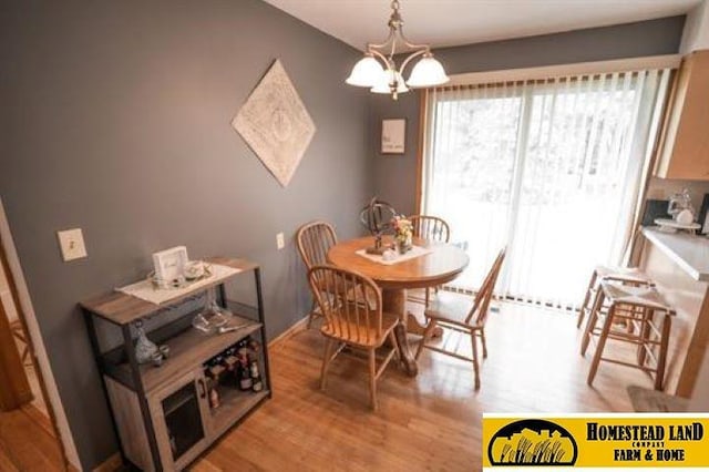 dining room with light hardwood / wood-style floors and an inviting chandelier