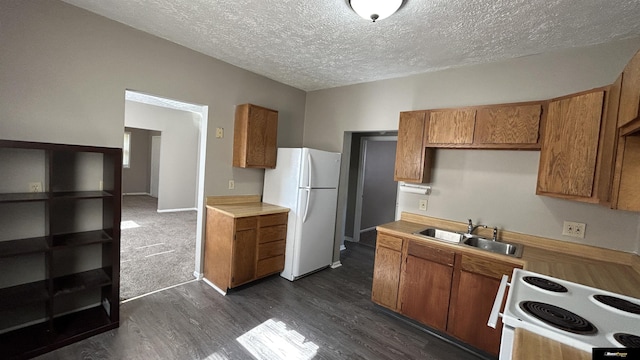 kitchen with a textured ceiling, dark hardwood / wood-style flooring, sink, and white appliances