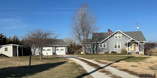 view of front facade with an outbuilding, a garage, and a front lawn