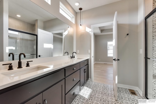 bathroom with hardwood / wood-style floors, vanity, and a shower with shower door