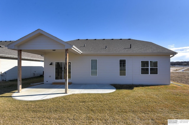 back of property with a lawn and a patio