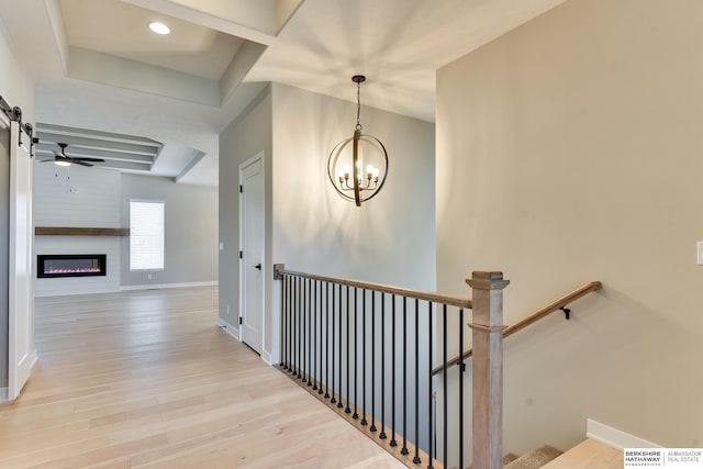 corridor with light hardwood / wood-style floors and a chandelier