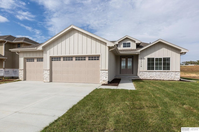 view of front of home with a front yard, french doors, and a garage