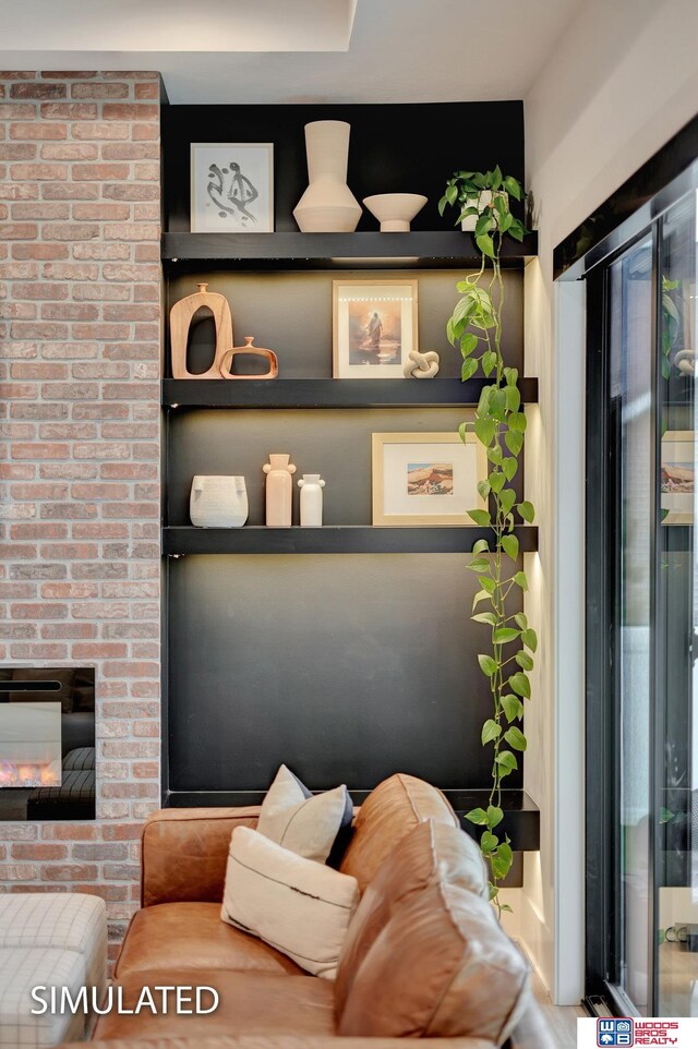 living room with built in shelves and a brick fireplace