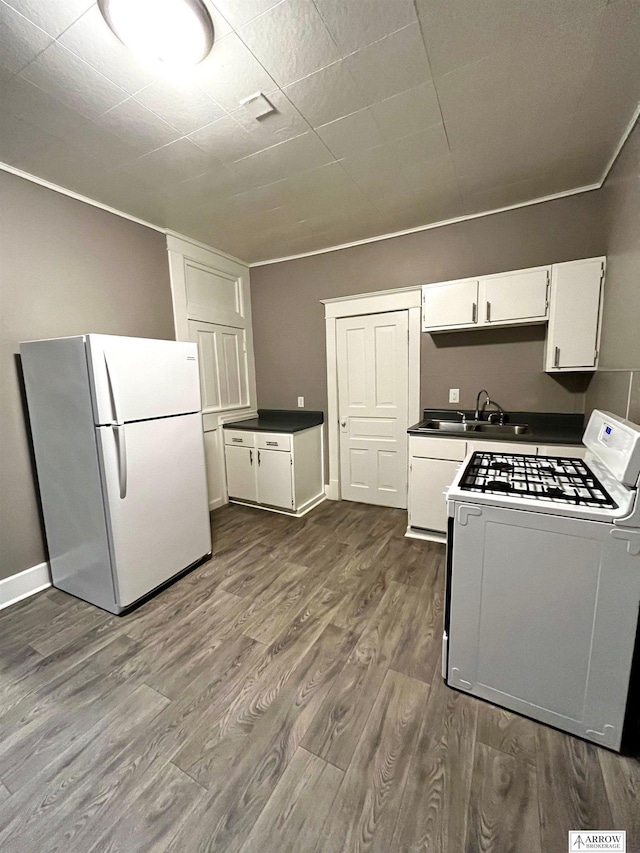 kitchen featuring white cabinets, white appliances, dark hardwood / wood-style floors, and sink