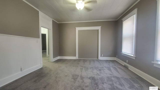 carpeted empty room featuring ceiling fan and ornamental molding