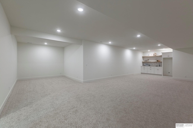 basement with light carpet and indoor bar