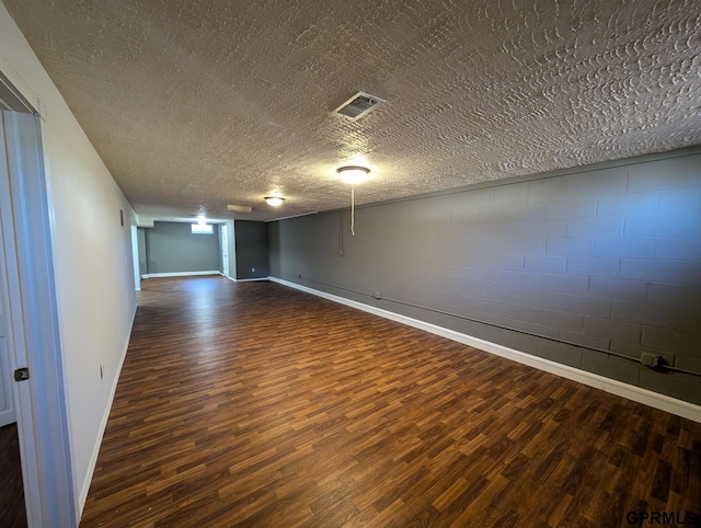 empty room with dark hardwood / wood-style floors and a textured ceiling