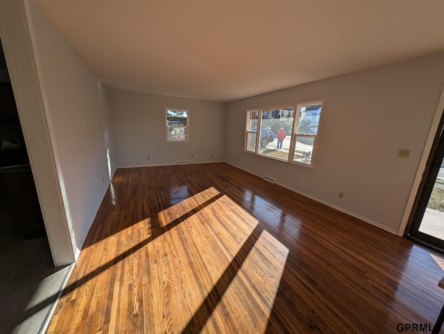 unfurnished living room featuring dark wood-type flooring