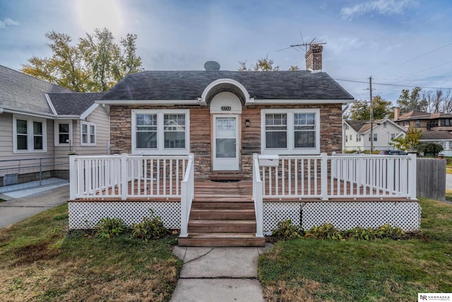 bungalow-style house featuring a wooden deck and a front yard