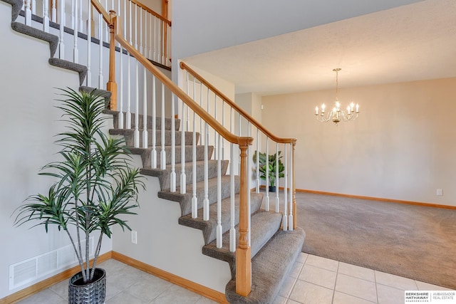 stairway with carpet flooring and an inviting chandelier