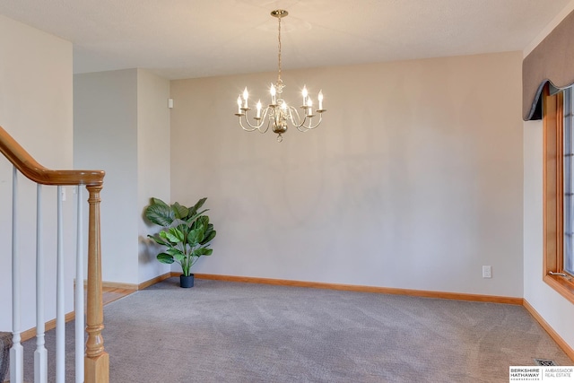 carpeted spare room with a chandelier