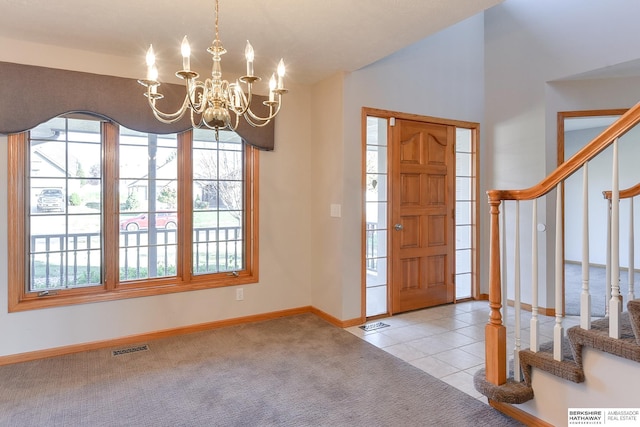 entrance foyer with light tile patterned floors and an inviting chandelier