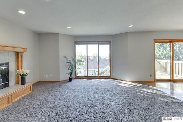 unfurnished living room featuring carpet floors and a tiled fireplace